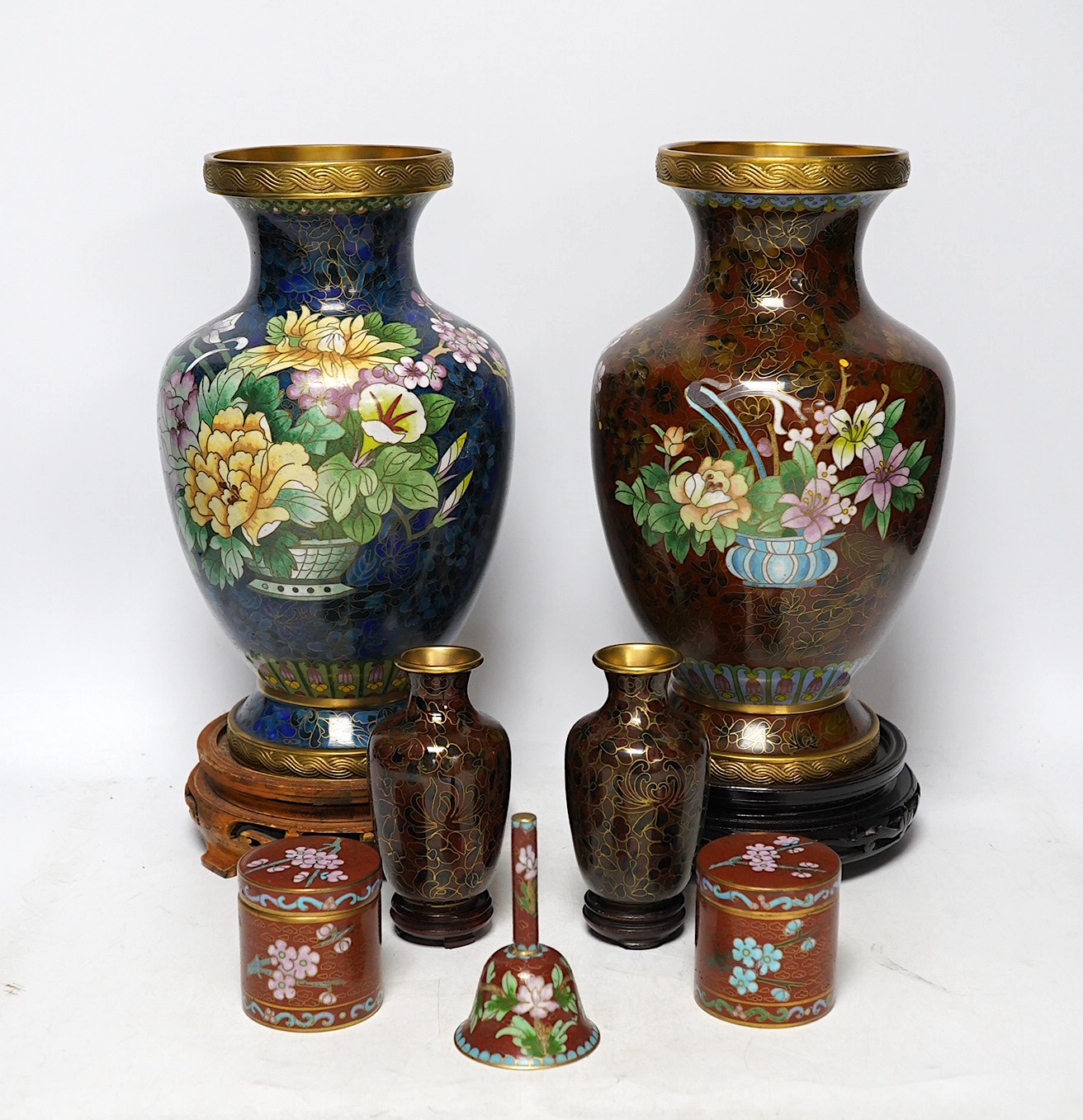 Two large Chinese cloisonné vases with hardwood stands, a smaller pair of vases, a pair of similar boxes and covers and a small table bell, tallest 31cm. Condition - fair to good